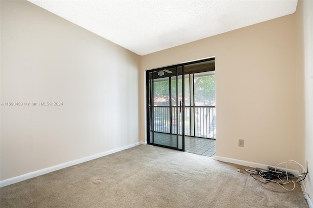 carpeted empty room with a textured ceiling