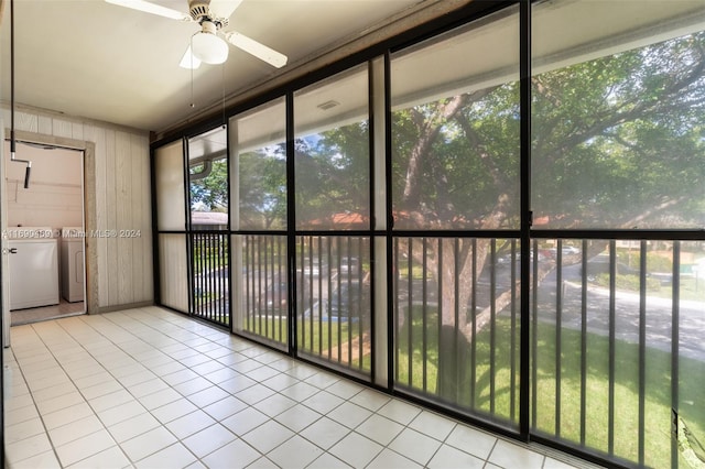 unfurnished sunroom with ceiling fan and washing machine and clothes dryer