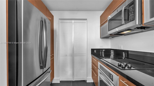 kitchen with dark tile patterned floors and stainless steel appliances