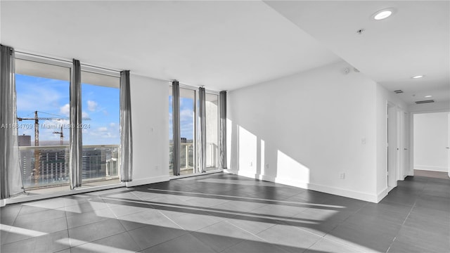 tiled spare room featuring floor to ceiling windows