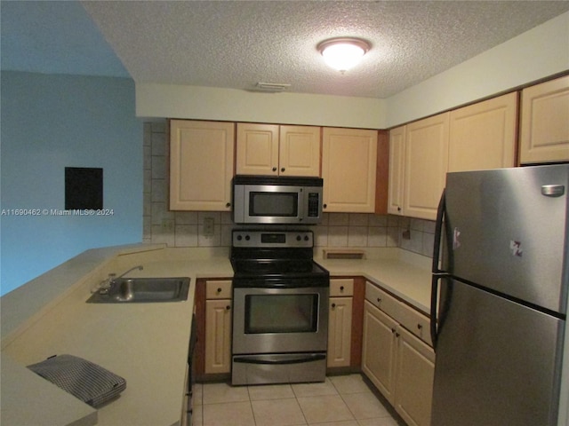 kitchen with kitchen peninsula, stainless steel appliances, sink, and tasteful backsplash