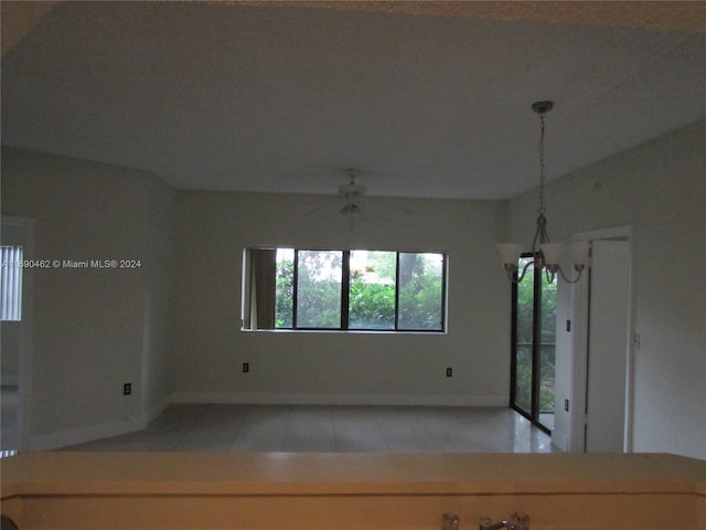 tiled empty room with lofted ceiling and ceiling fan