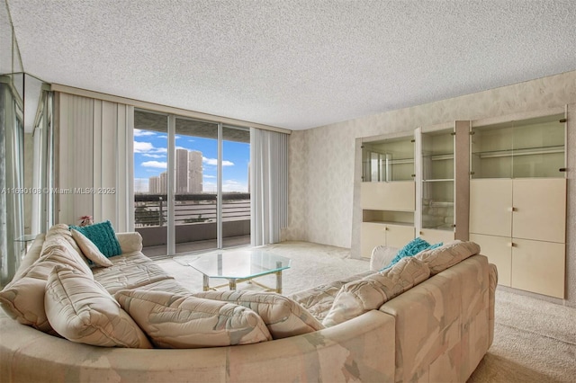 living room featuring light colored carpet, a wall of windows, and a textured ceiling