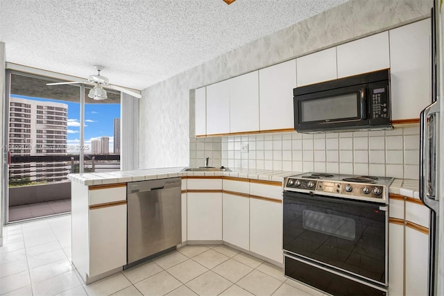 kitchen featuring white cabinets, electric range, black microwave, a textured ceiling, and stainless steel dishwasher
