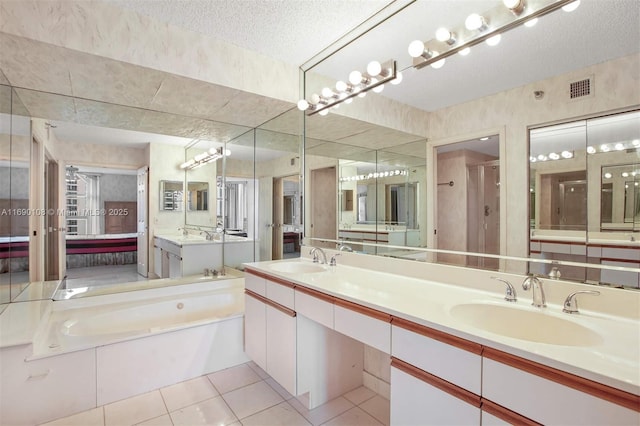 bathroom with a sink, tile patterned flooring, a textured ceiling, and visible vents