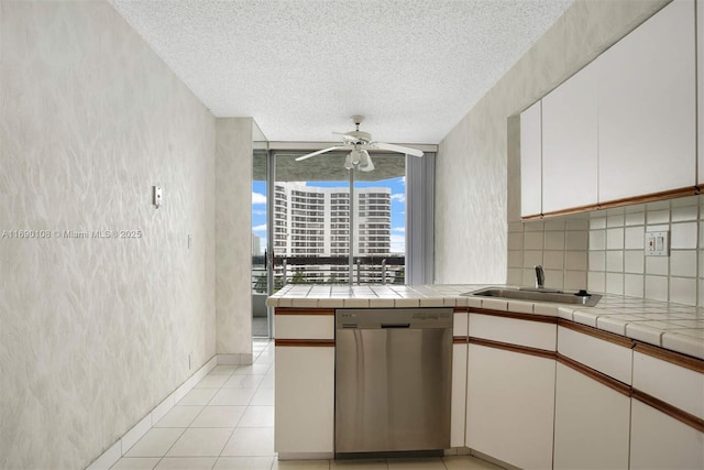 kitchen with light tile patterned floors, decorative backsplash, ceiling fan, stainless steel dishwasher, and a sink