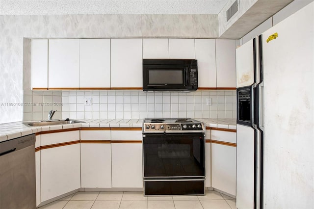 kitchen with range with electric stovetop, stainless steel dishwasher, a sink, white fridge with ice dispenser, and black microwave