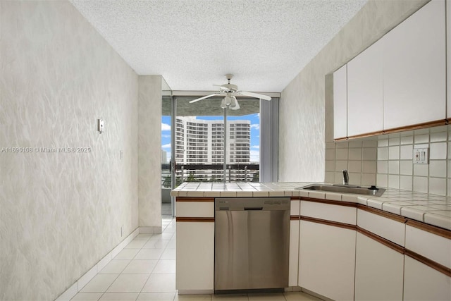 kitchen with a sink, a textured ceiling, a ceiling fan, and dishwasher