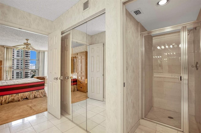 full bath featuring a textured ceiling, tile patterned flooring, visible vents, a shower stall, and ensuite bath