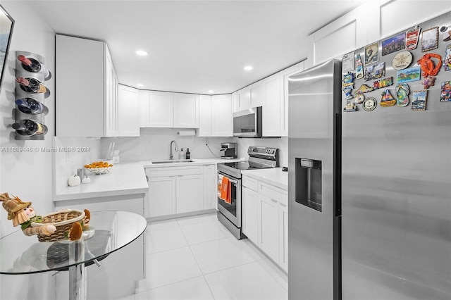 kitchen featuring light tile patterned flooring, stainless steel appliances, white cabinetry, and sink