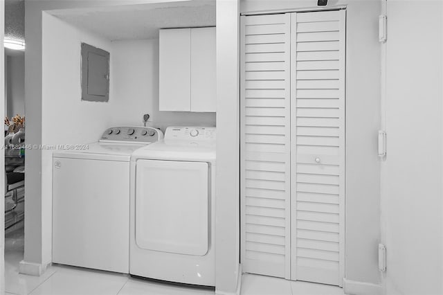 laundry area featuring electric panel, light tile patterned floors, cabinets, and independent washer and dryer