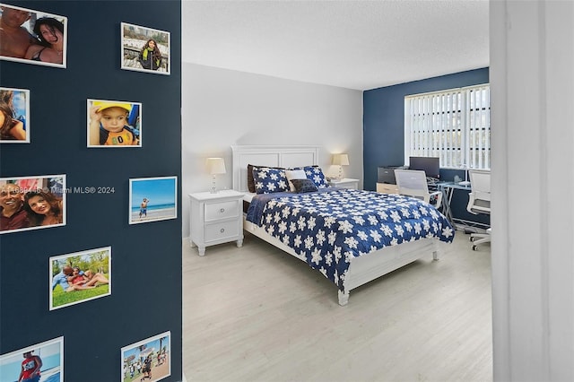 bedroom with light hardwood / wood-style flooring and a textured ceiling