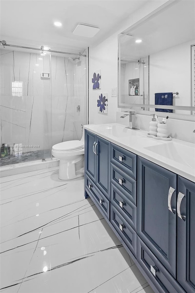 bathroom featuring tile patterned flooring, vanity, toilet, and a shower with door