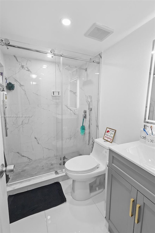 bathroom featuring tile patterned floors, vanity, an enclosed shower, and toilet