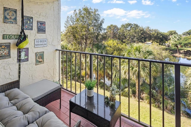 balcony featuring an outdoor living space and a water view