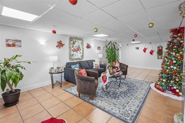 tiled living room featuring a paneled ceiling