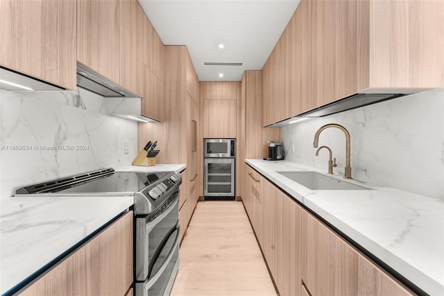 kitchen featuring light brown cabinets, stainless steel appliances, light hardwood / wood-style floors, and sink