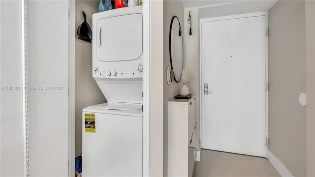 washroom featuring light tile patterned floors and stacked washing maching and dryer