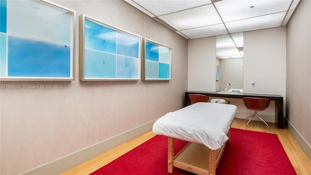 bathroom with hardwood / wood-style floors and a paneled ceiling