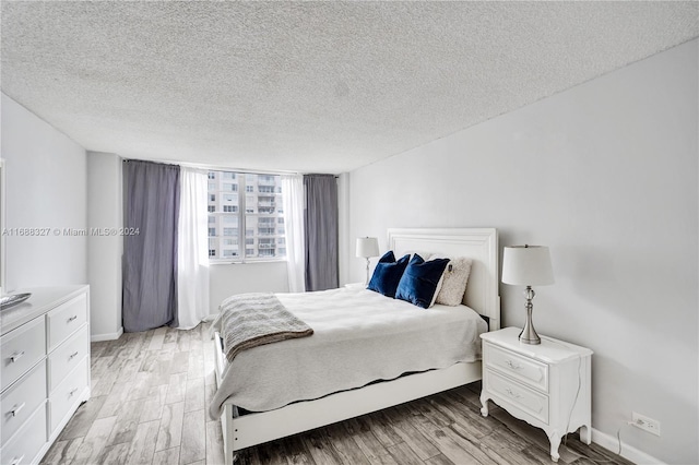 bedroom featuring light wood-type flooring and a textured ceiling