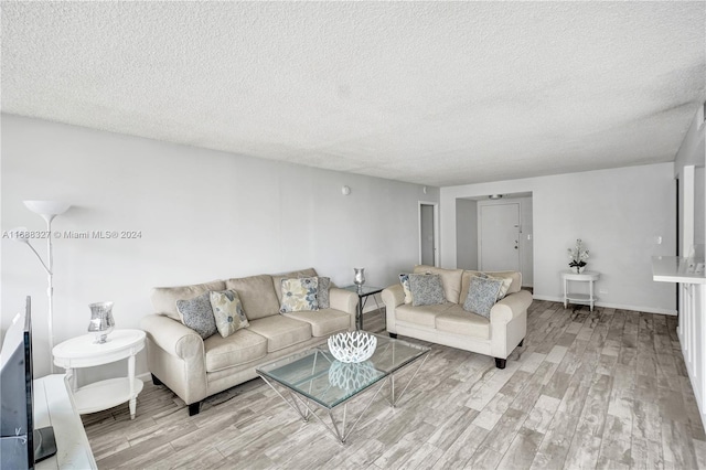 living room with light hardwood / wood-style floors and a textured ceiling