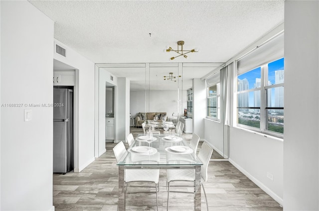 dining room with light hardwood / wood-style flooring and a textured ceiling