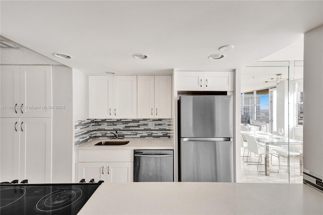 kitchen with white cabinets, sink, stainless steel appliances, and tasteful backsplash