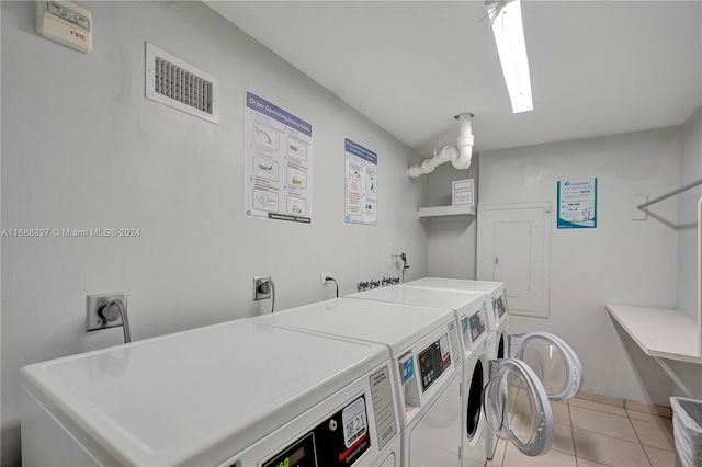 laundry area featuring washer and dryer and light tile patterned floors