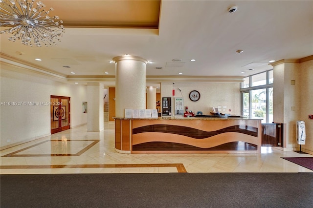 welcome area featuring a chandelier and decorative columns