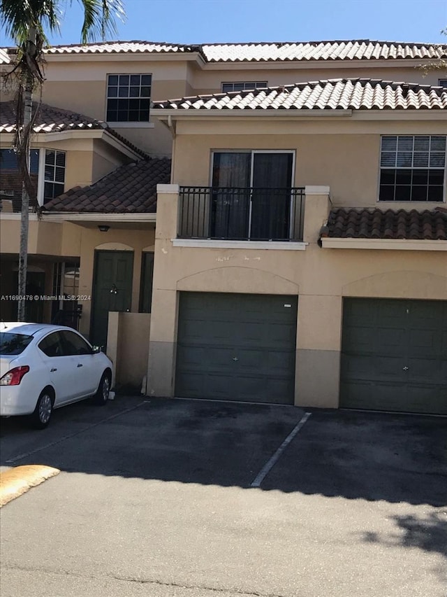 view of front of house featuring a garage and a balcony