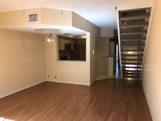 unfurnished room featuring dark wood-type flooring and a chandelier