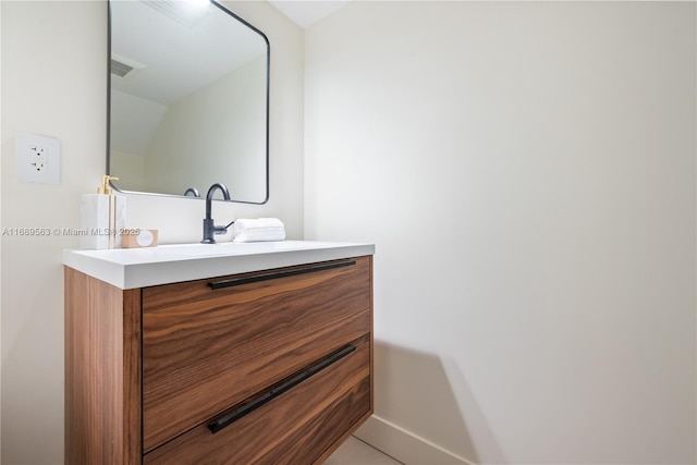 bathroom featuring visible vents, vanity, and baseboards