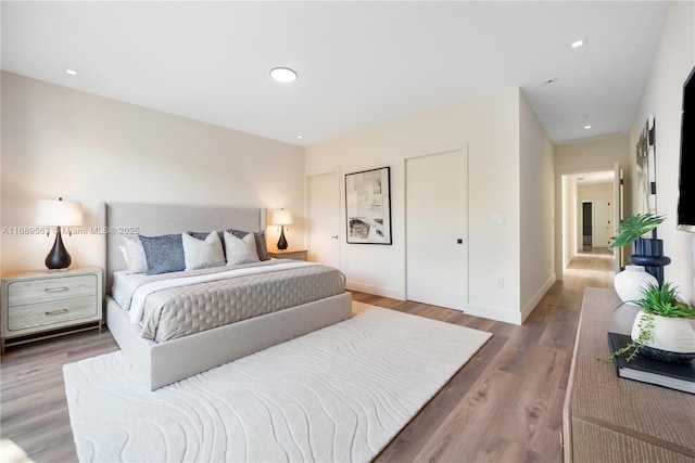 bedroom with recessed lighting, baseboards, and wood finished floors