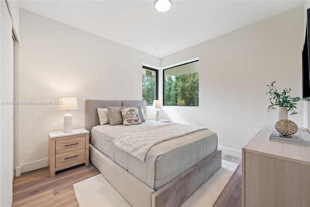 bedroom featuring baseboards and wood finished floors