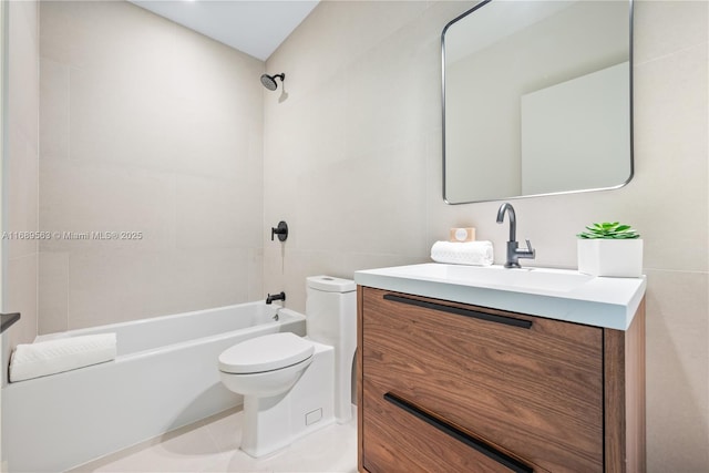 bathroom with toilet, tile patterned flooring, tub / shower combination, vanity, and tile walls