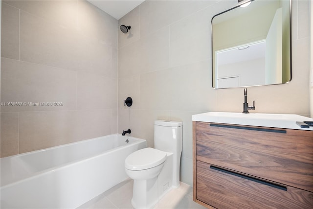 full bathroom featuring toilet, tile patterned flooring, tub / shower combination, vanity, and tile walls