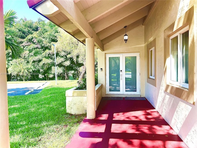 doorway to property featuring a lawn and french doors