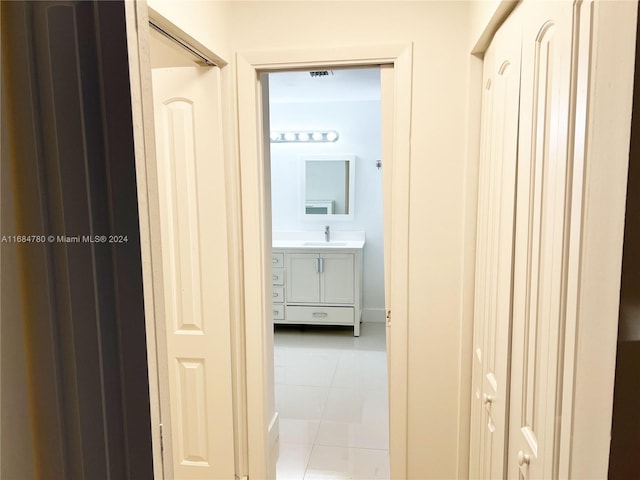 hall featuring light tile patterned floors and sink