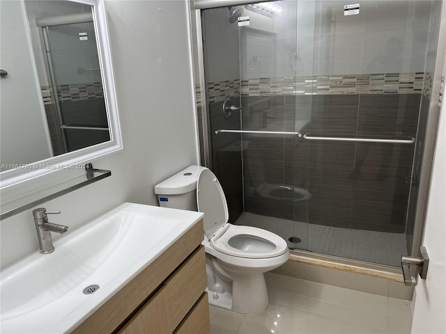 bathroom featuring vanity, a shower with door, tile patterned floors, and toilet