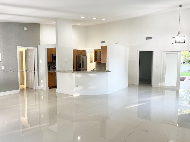 interior space with light tile patterned floors and a high ceiling