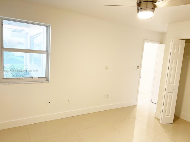 tiled spare room featuring ceiling fan