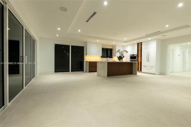 interior space featuring a raised ceiling and sink