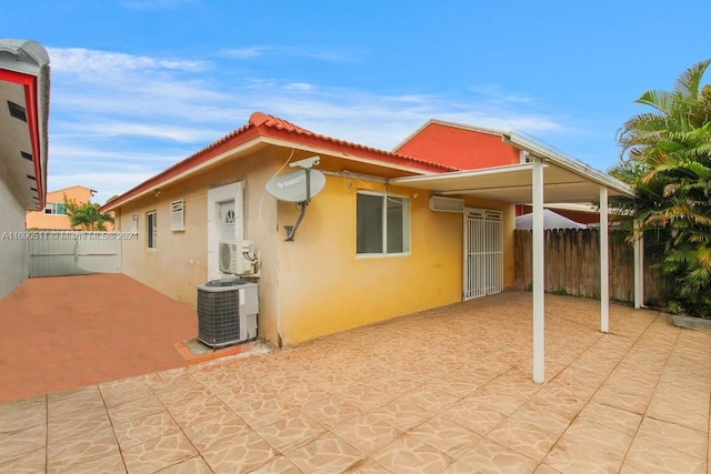 rear view of property featuring central AC unit, ac unit, and a patio area