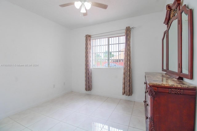 tiled empty room featuring ceiling fan