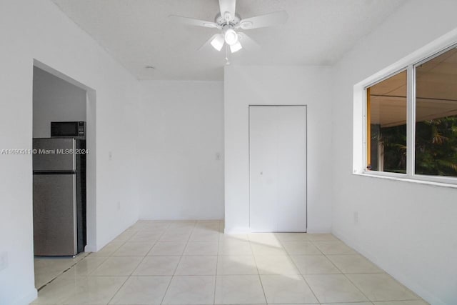 spare room featuring light tile patterned flooring and ceiling fan