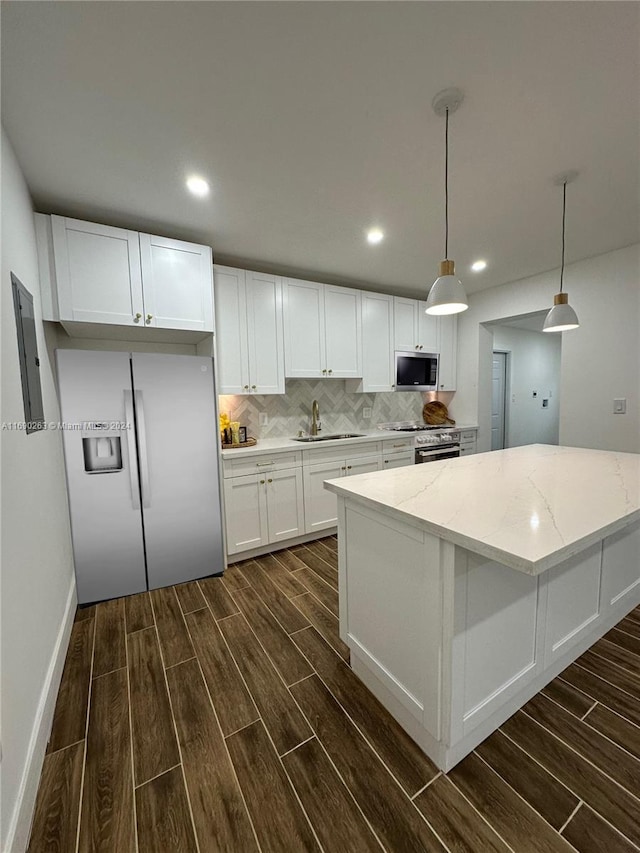 kitchen with white cabinets, appliances with stainless steel finishes, dark wood-type flooring, and pendant lighting