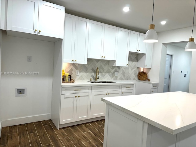 kitchen featuring decorative light fixtures, white cabinetry, dark wood-type flooring, and sink