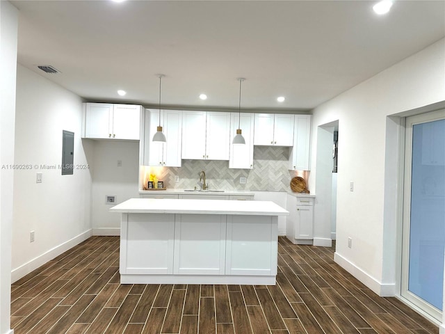 kitchen featuring white cabinets, dark hardwood / wood-style flooring, a kitchen island, and sink