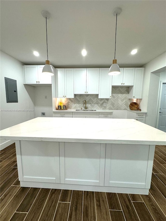 kitchen with white cabinetry, electric panel, and light stone counters