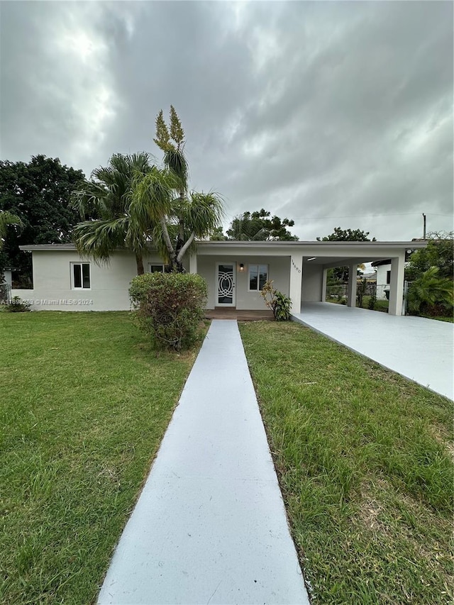 view of front facade with a front yard and a carport